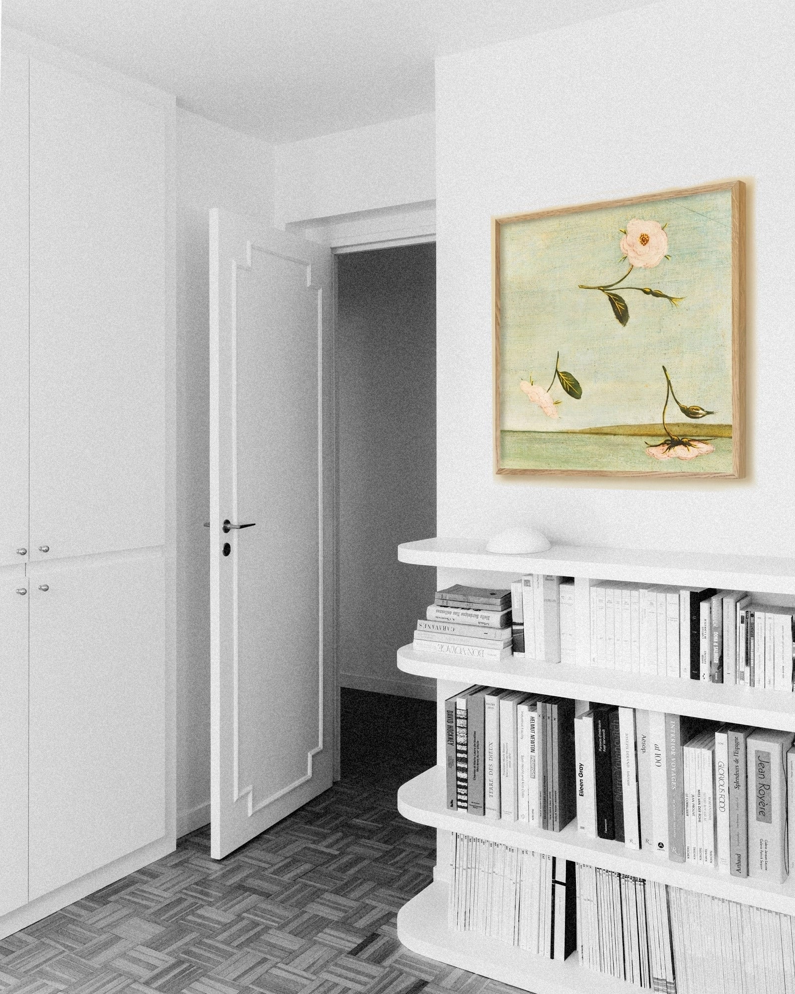 Room interior with a bookshelf and a painting of flowers on the wall.